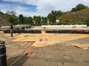 Construction worker on a building roof renovation site.