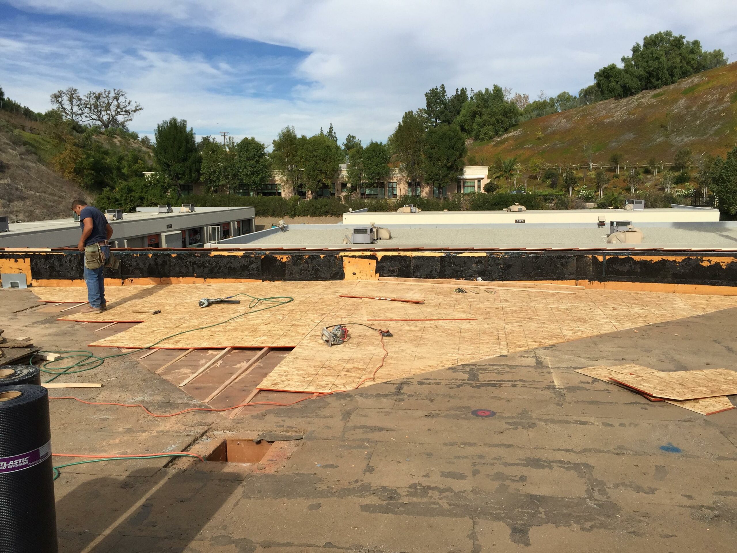 Construction worker on a building roof renovation site.