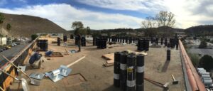 Construction site with workers and materials on roof.