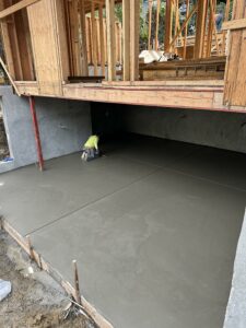 Worker smoothing concrete at construction site