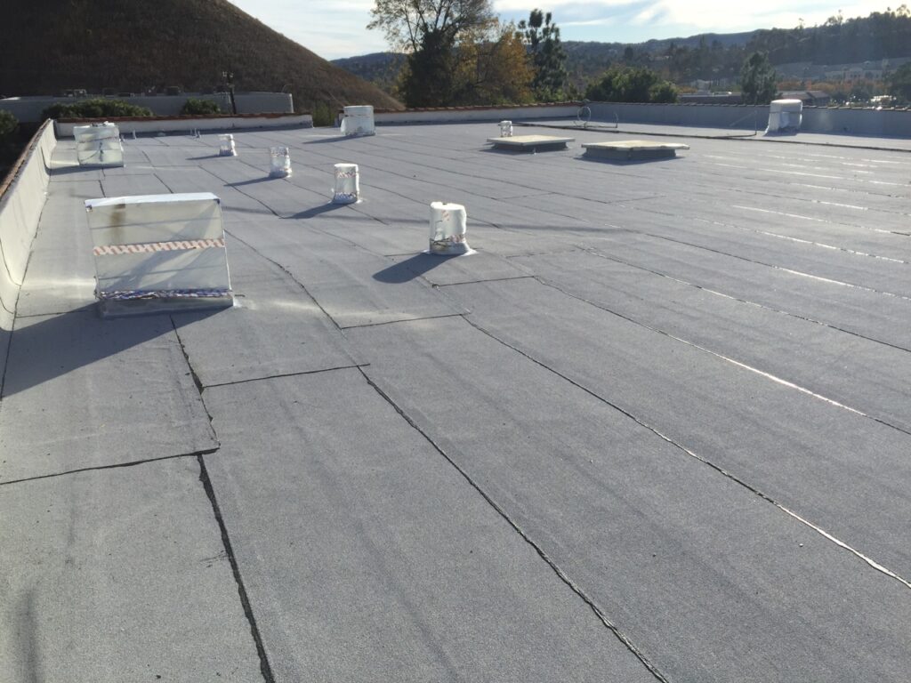 Flat commercial roof with ventilation units and skylights.
