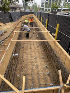 Construction workers installing rebar for concrete foundation.