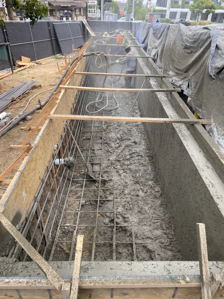 Concrete foundation construction site with workers.