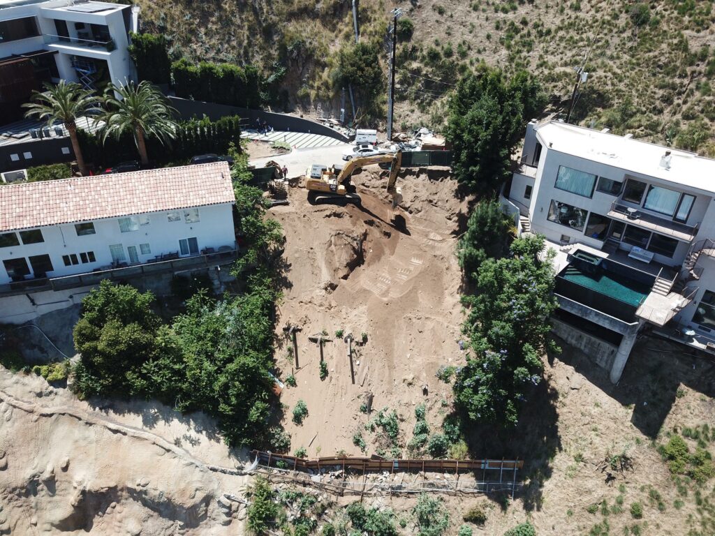 Aerial view of construction site excavating near residential buildings.
