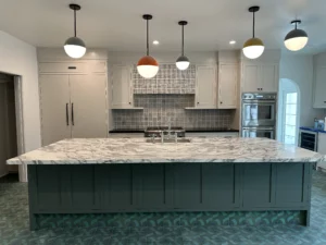 Modern kitchen interior with island and pendant lights.