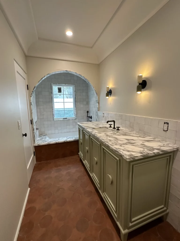 Elegant bathroom with terracotta tiles and white vanity.