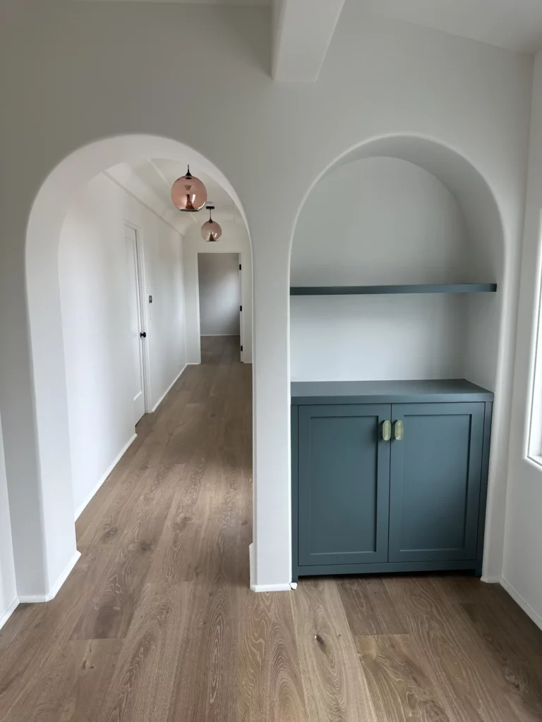 Hallway with arched doorways and pendant lights.
