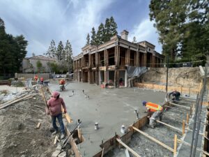 Construction workers pouring concrete at building site.