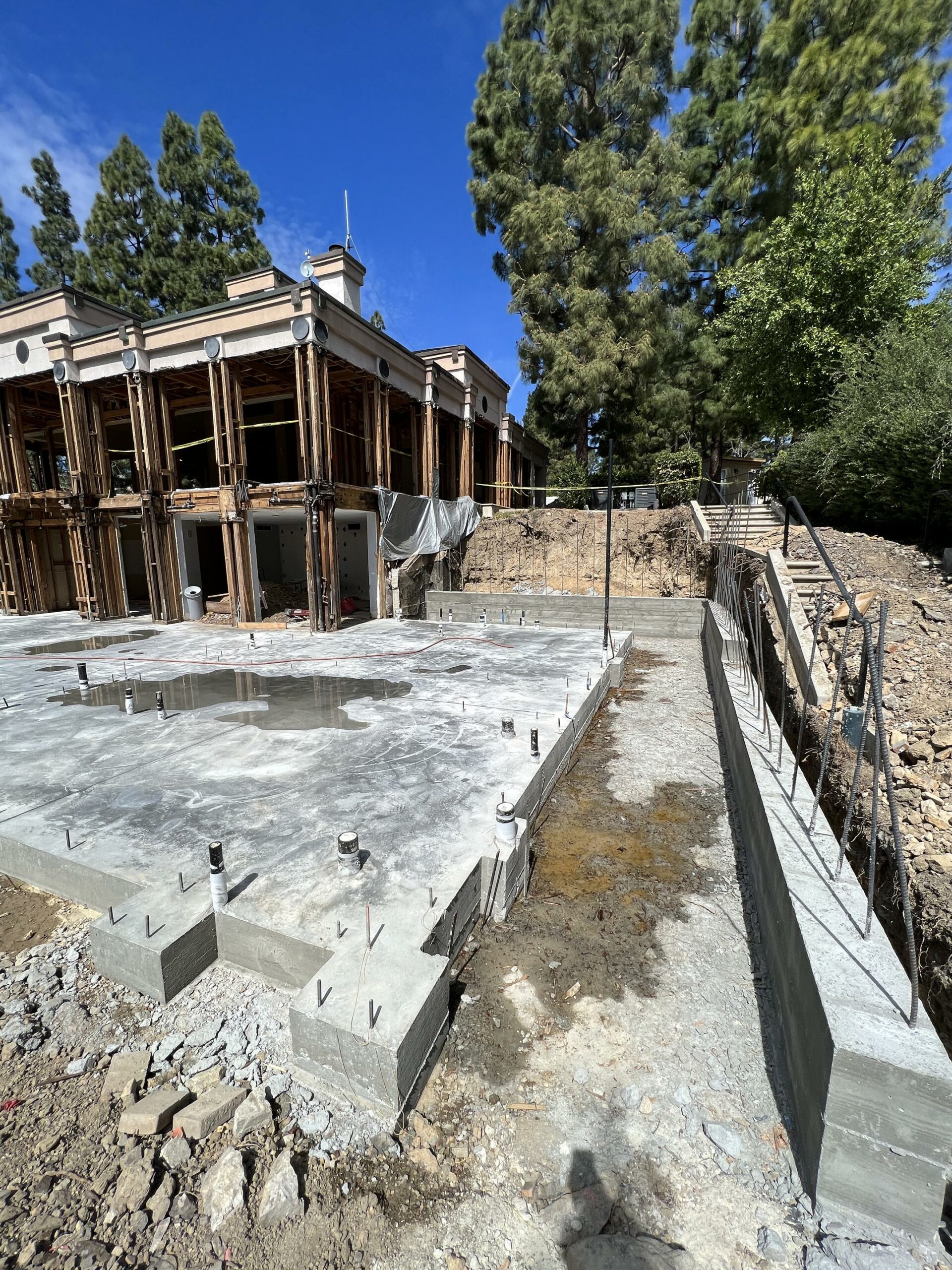 House construction site with concrete foundation and framing.
