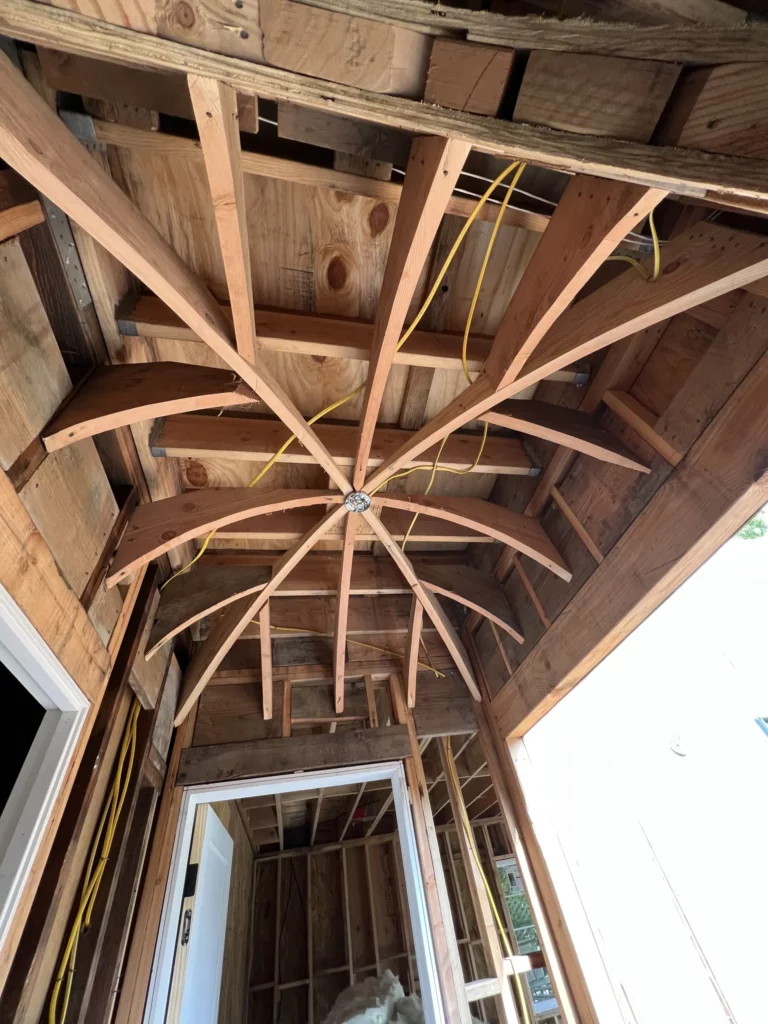 Wooden roof structure with exposed beams and wiring.