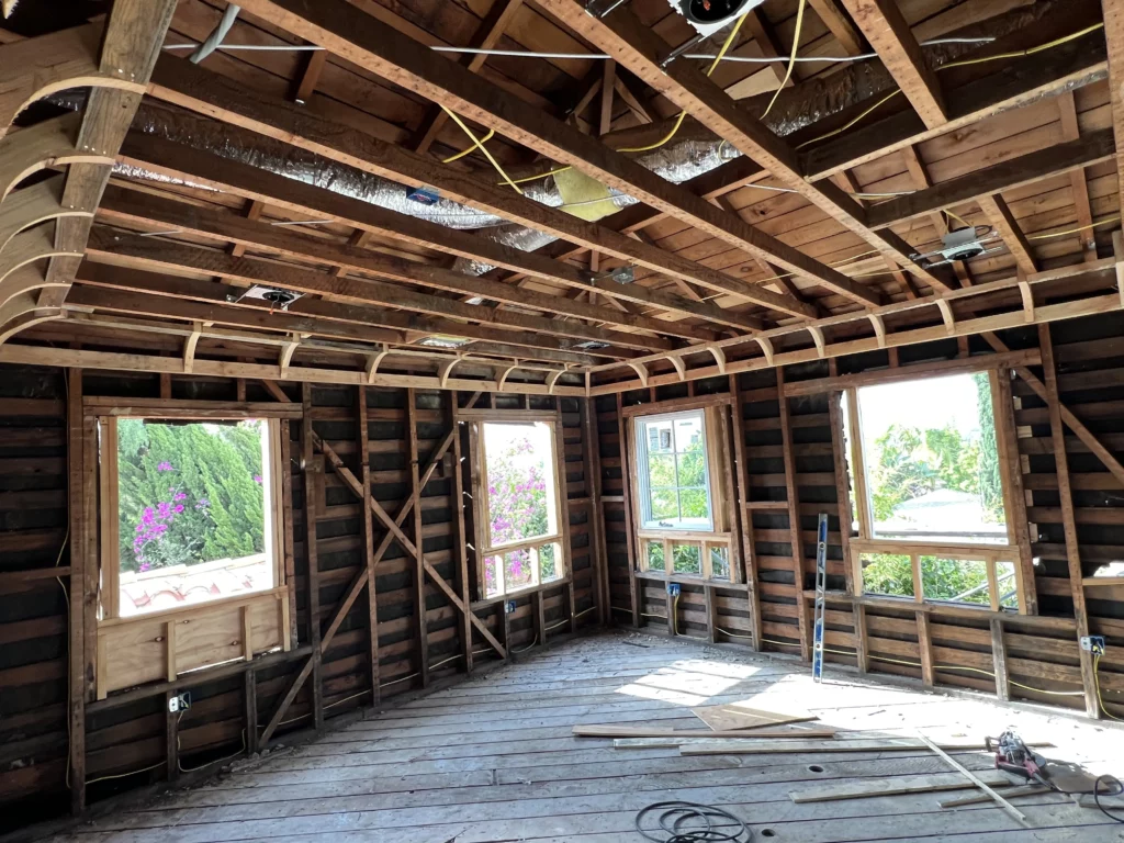 House interior during renovation, exposed wooden frame and insulation.
