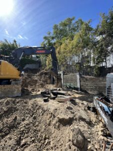 Excavator at construction site with dirt and debris.