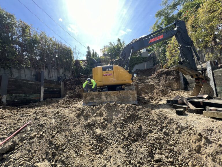Worker on excavator at construction site.