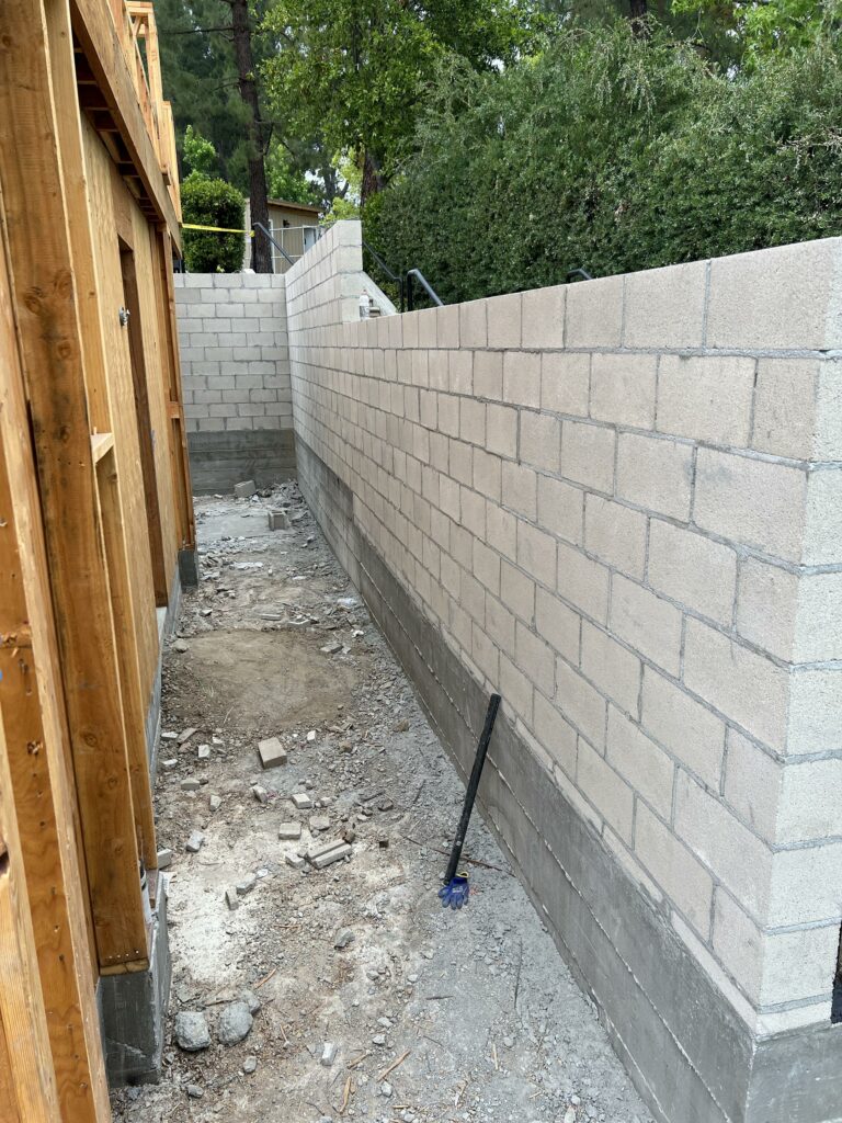 Construction site with unfinished cinder block wall.