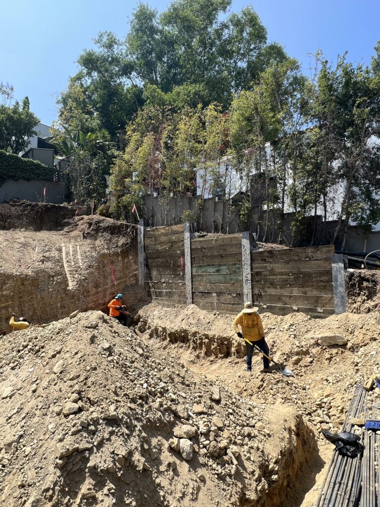 Construction site with workers and retaining wall.