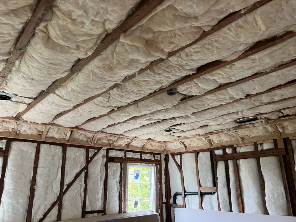Insulation installation in unfinished house interior.