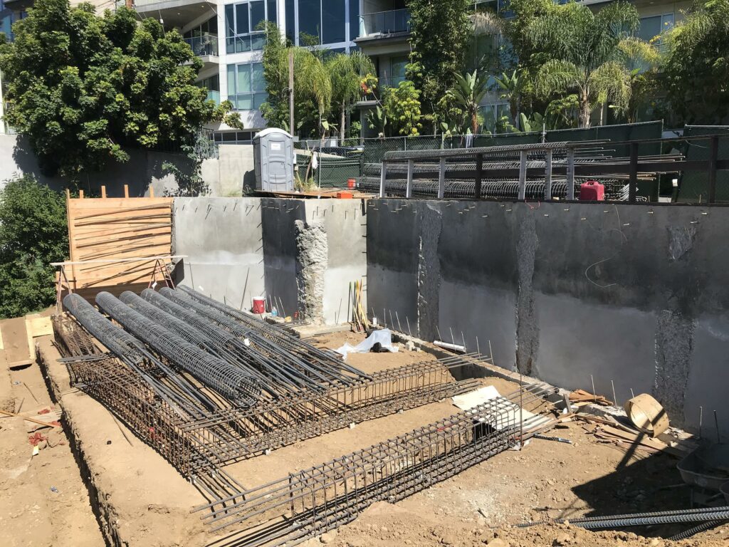 Construction site with concrete foundation and rebar setup.