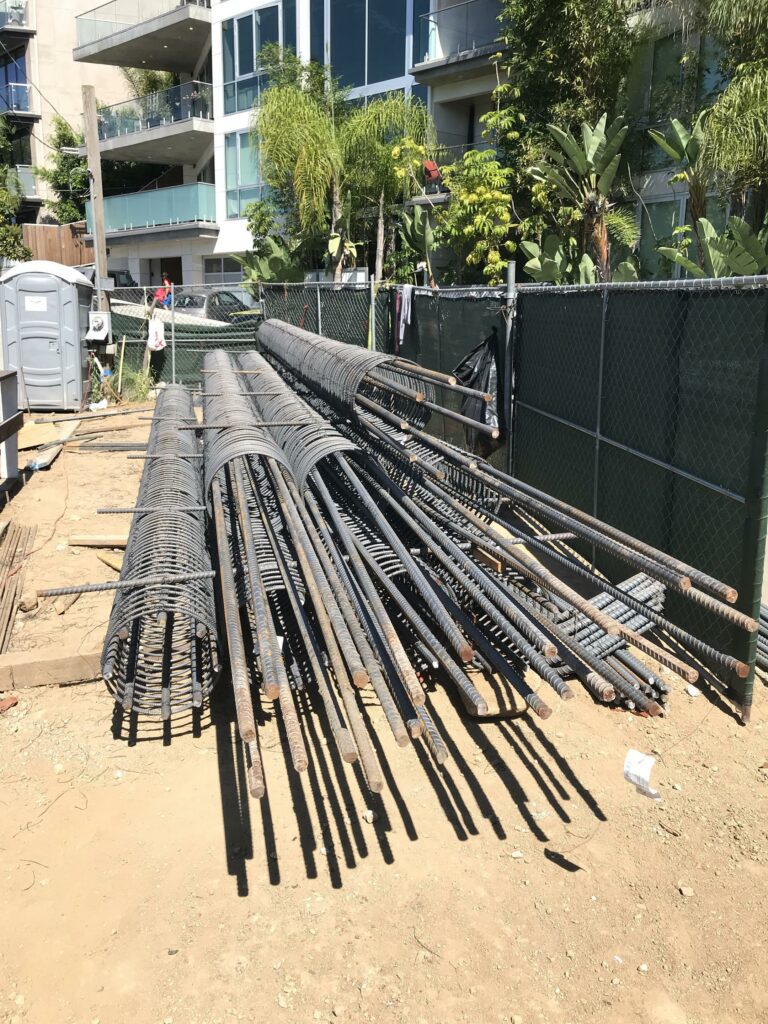 Construction rebar stacked at building site.