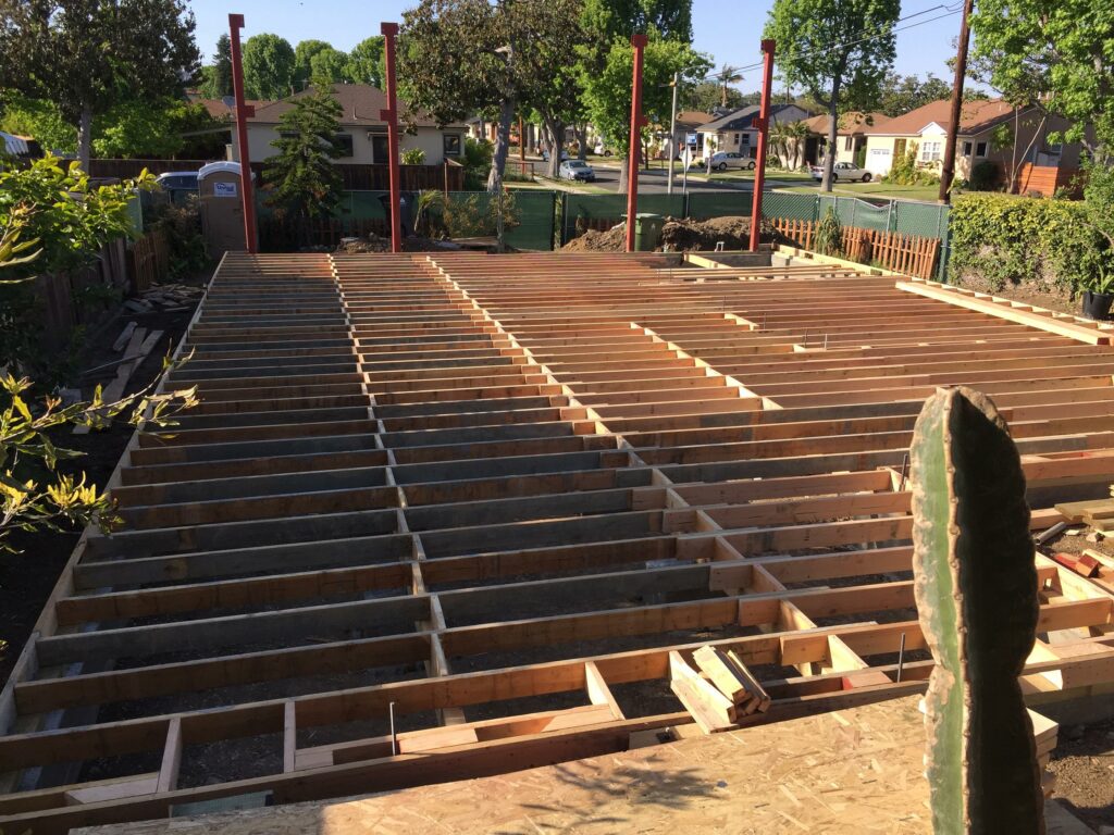 Construction of wooden deck frame in suburban backyard.
