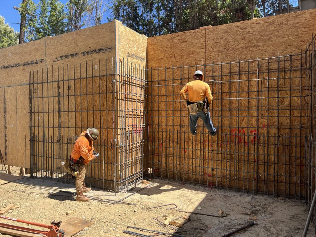Workers constructing a concrete reinforcement wall.