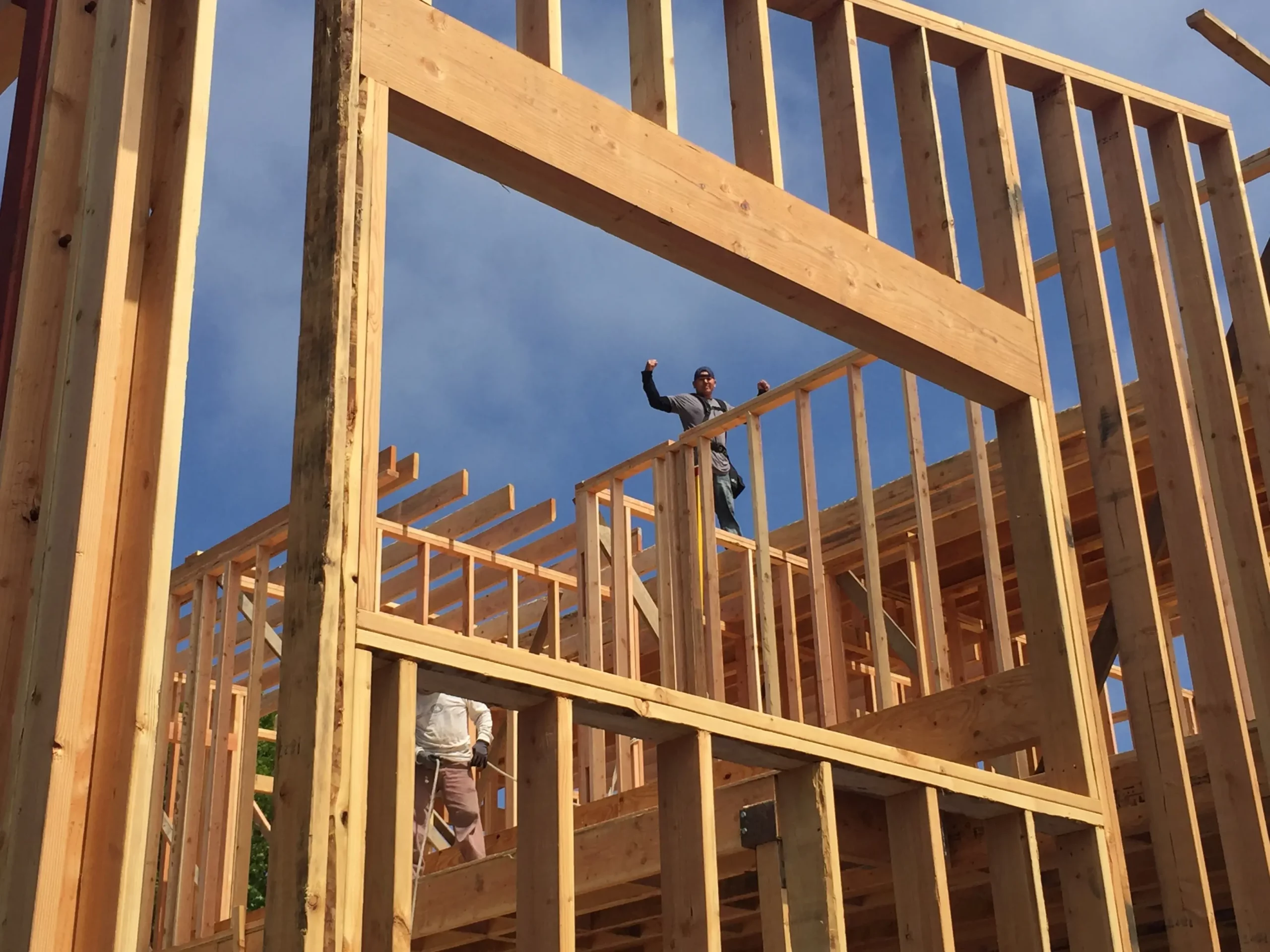 Construction workers building a wooden house frame.