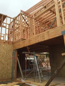 Wooden house frame construction with ladder.