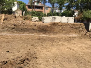 Excavation site for construction with stacked concrete blocks.