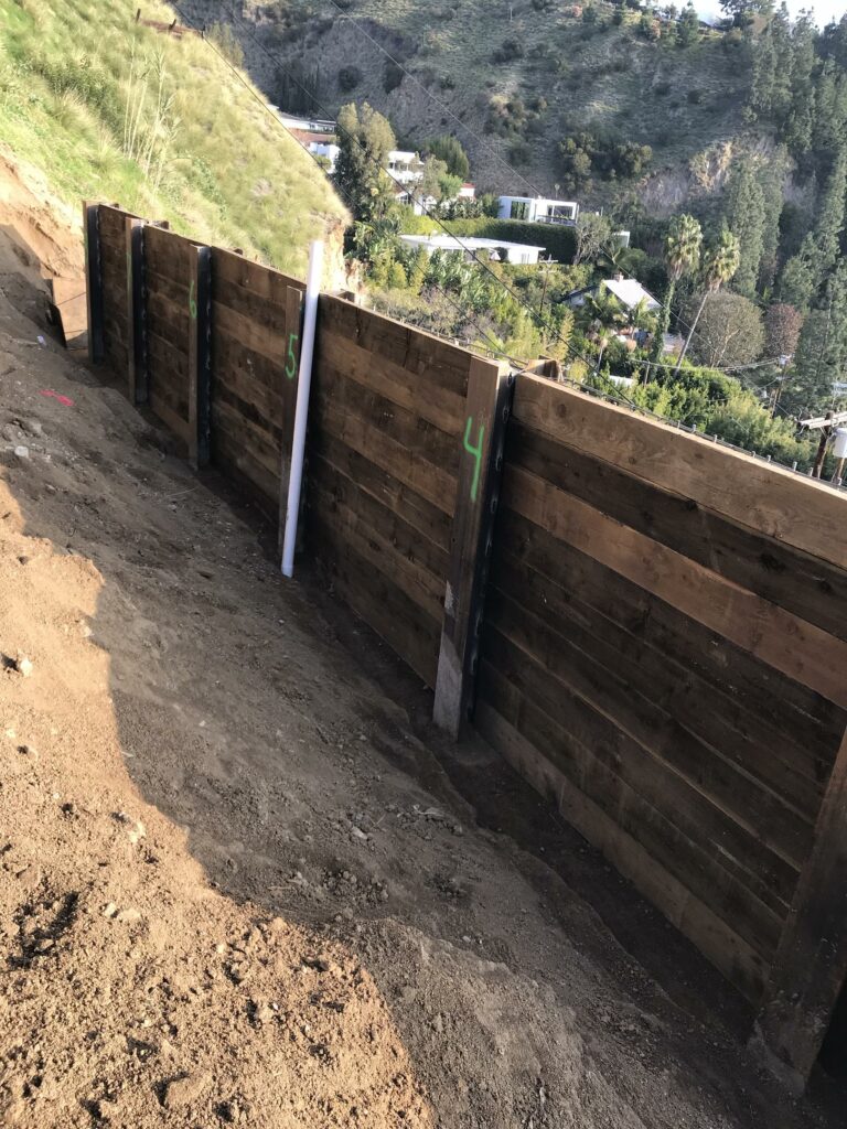 Retaining walls under construction on hillside with numbered supports.