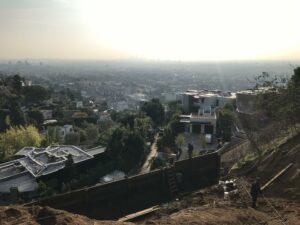 Sunrise over a hazy urban skyline with foreground construction.