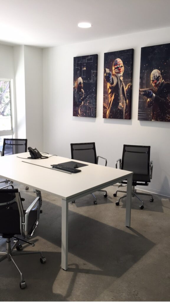 Modern office with artwork and conference table.