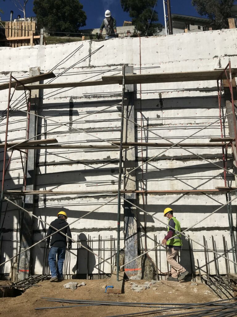 Construction workers on scaffolding at building site.
