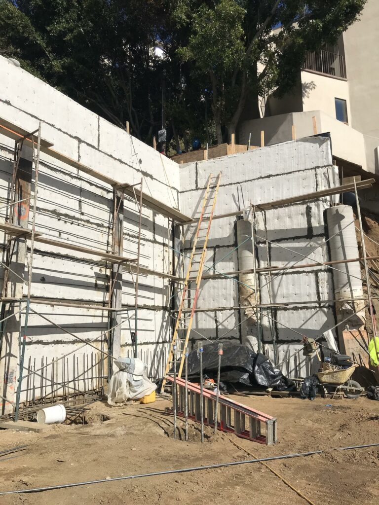 Construction site with scaffolding and concrete walls.