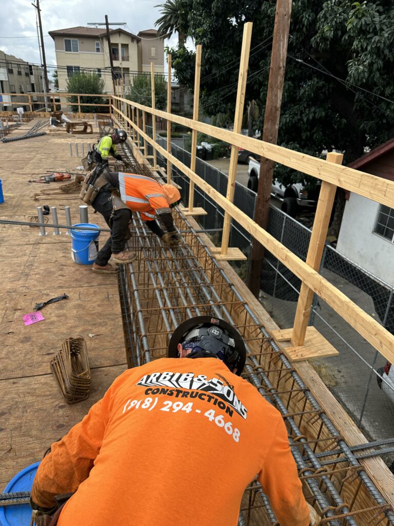 Construction workers reinforcing steel for concrete foundation.