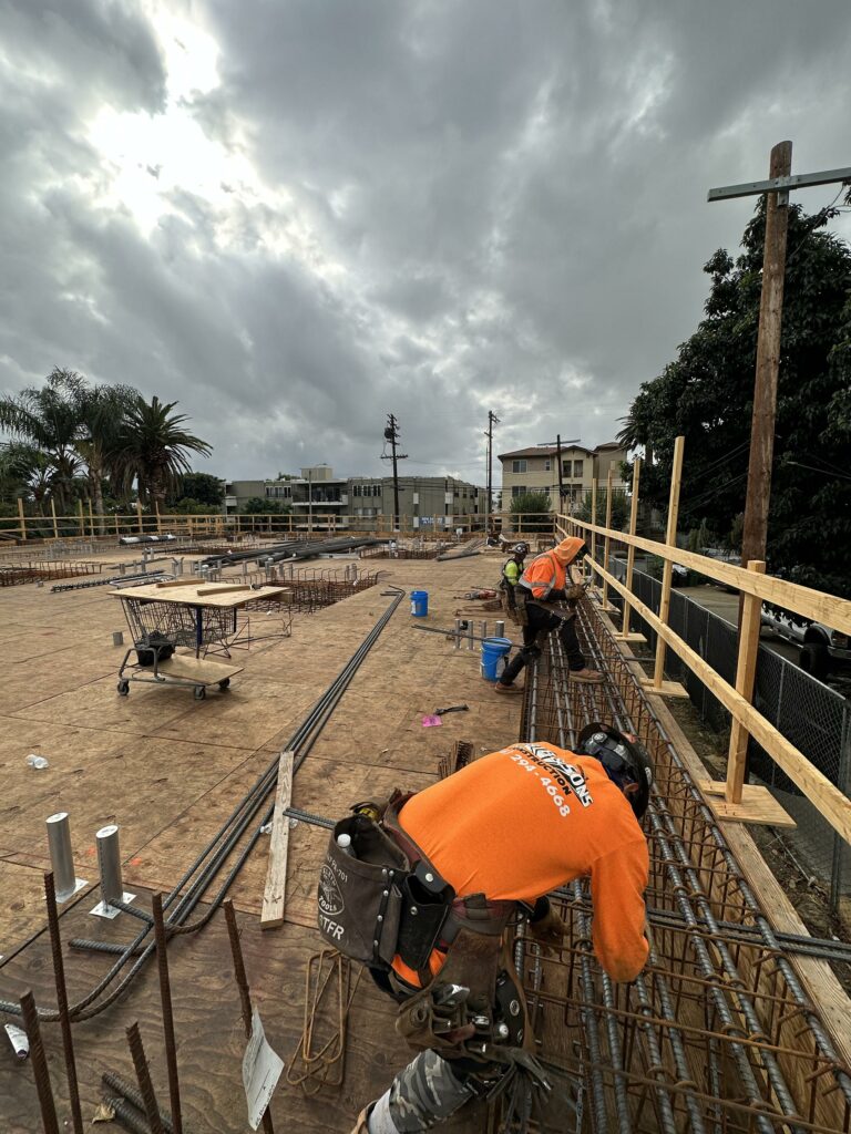 Construction workers on site with overcast skies