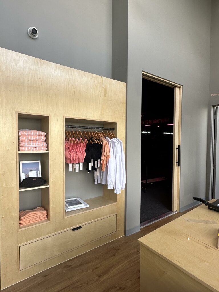 Modern apparel store interior with clothing display racks.