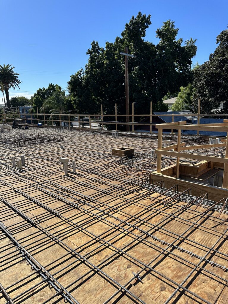 Construction site with rebar grid for concrete foundation.