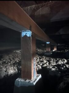 Crawlspace with illuminated wooden beam and support post