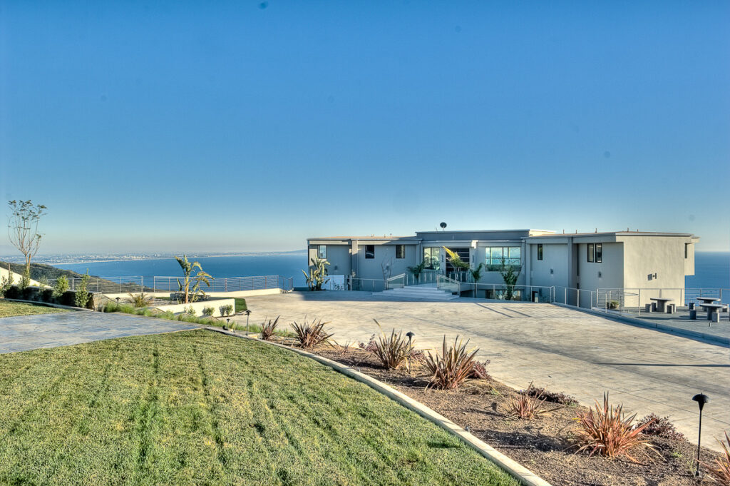Modern home overlooking ocean with landscaped garden.