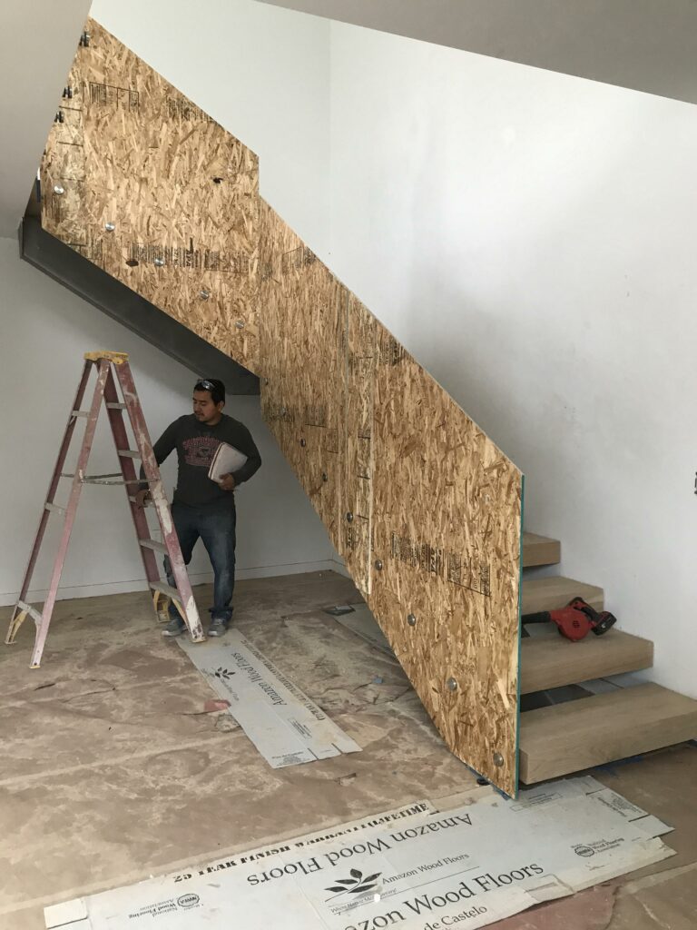 Man observing construction on unfinished wooden staircase