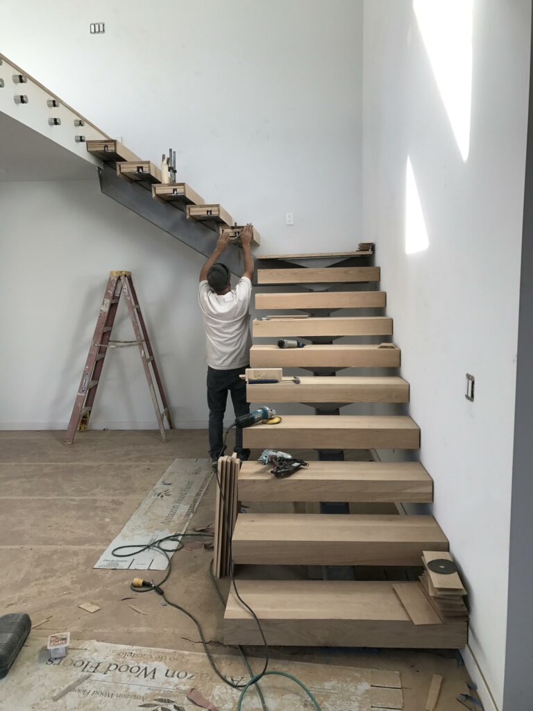 Person installing wooden stairs in home renovation.