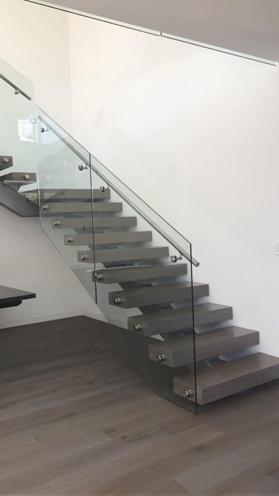 Modern floating staircase with glass railing.