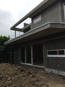 Modern house under construction with scaffolding.