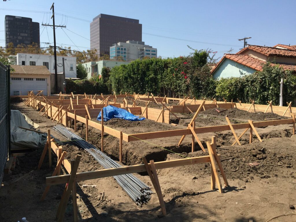 Urban construction site with wooden framework for foundations.