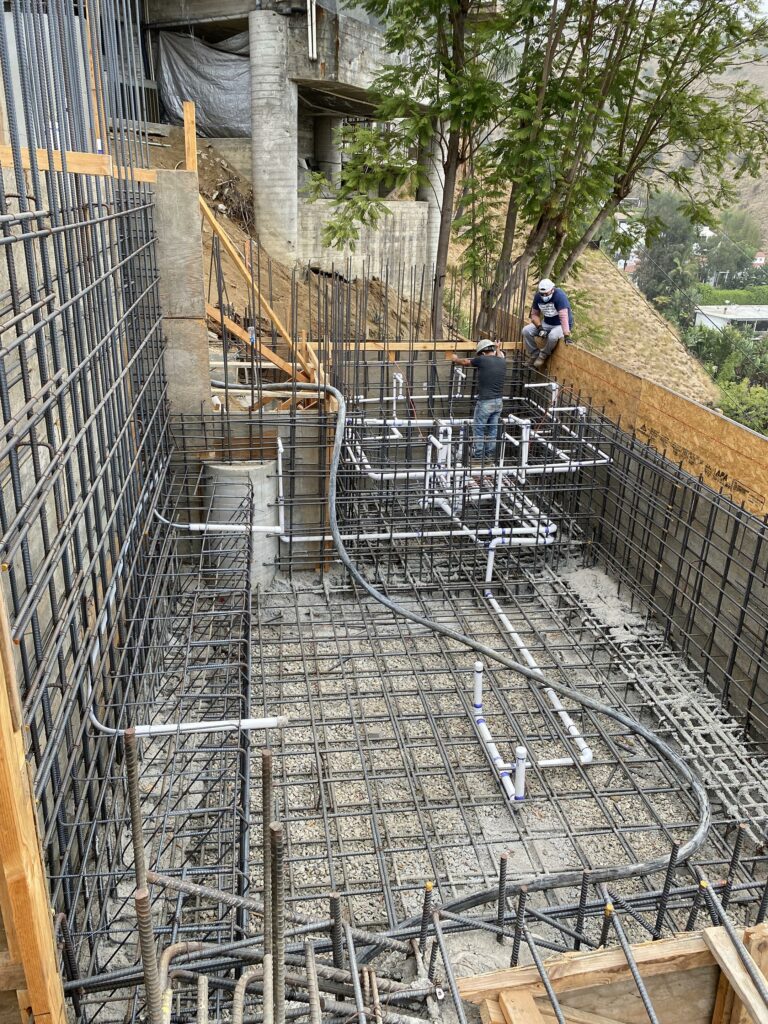 Construction site with rebar framework and workers.