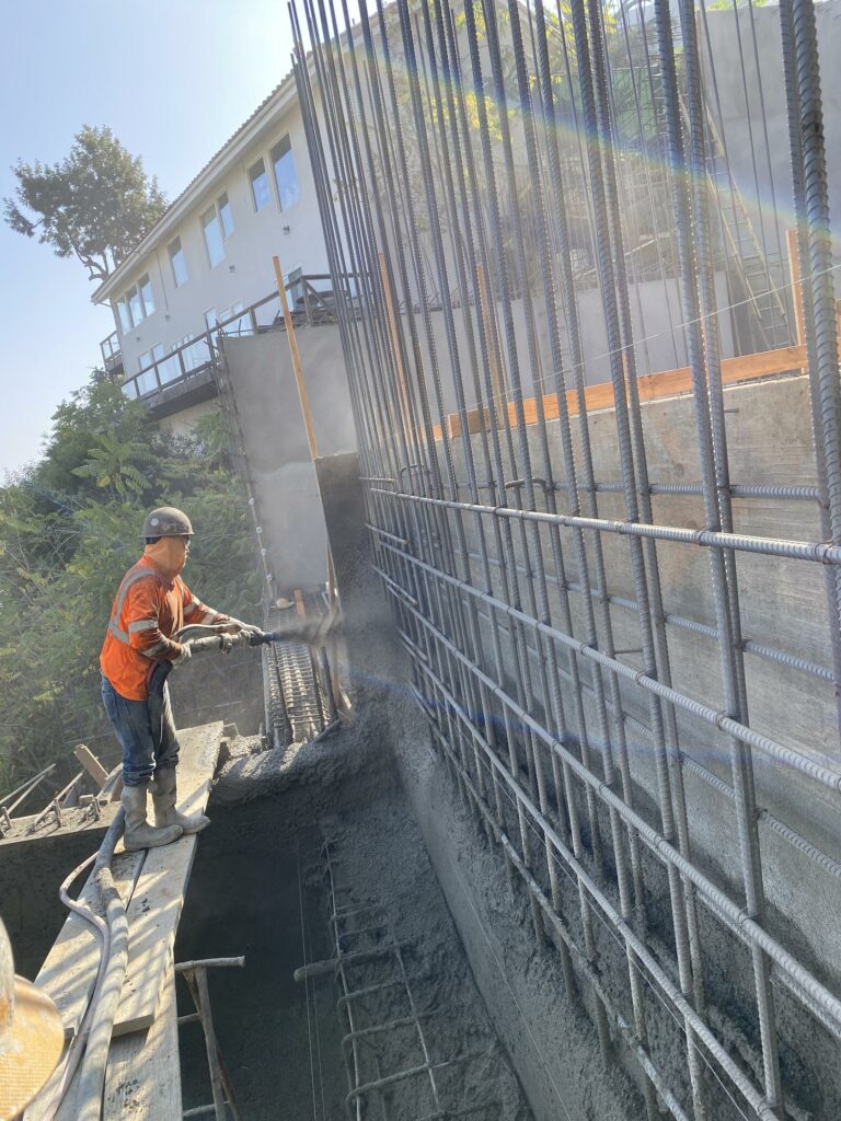 Worker pouring concrete at construction site.