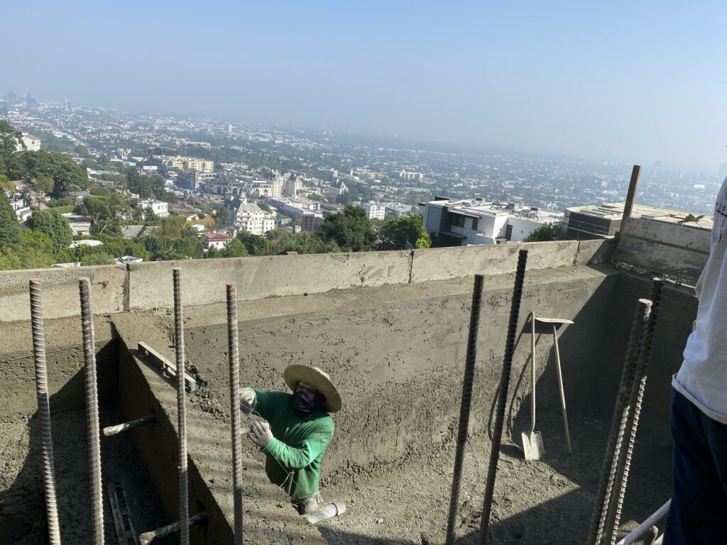 Worker constructing wall with cityscape background.
