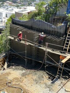 Workers constructing a concrete retaining wall.