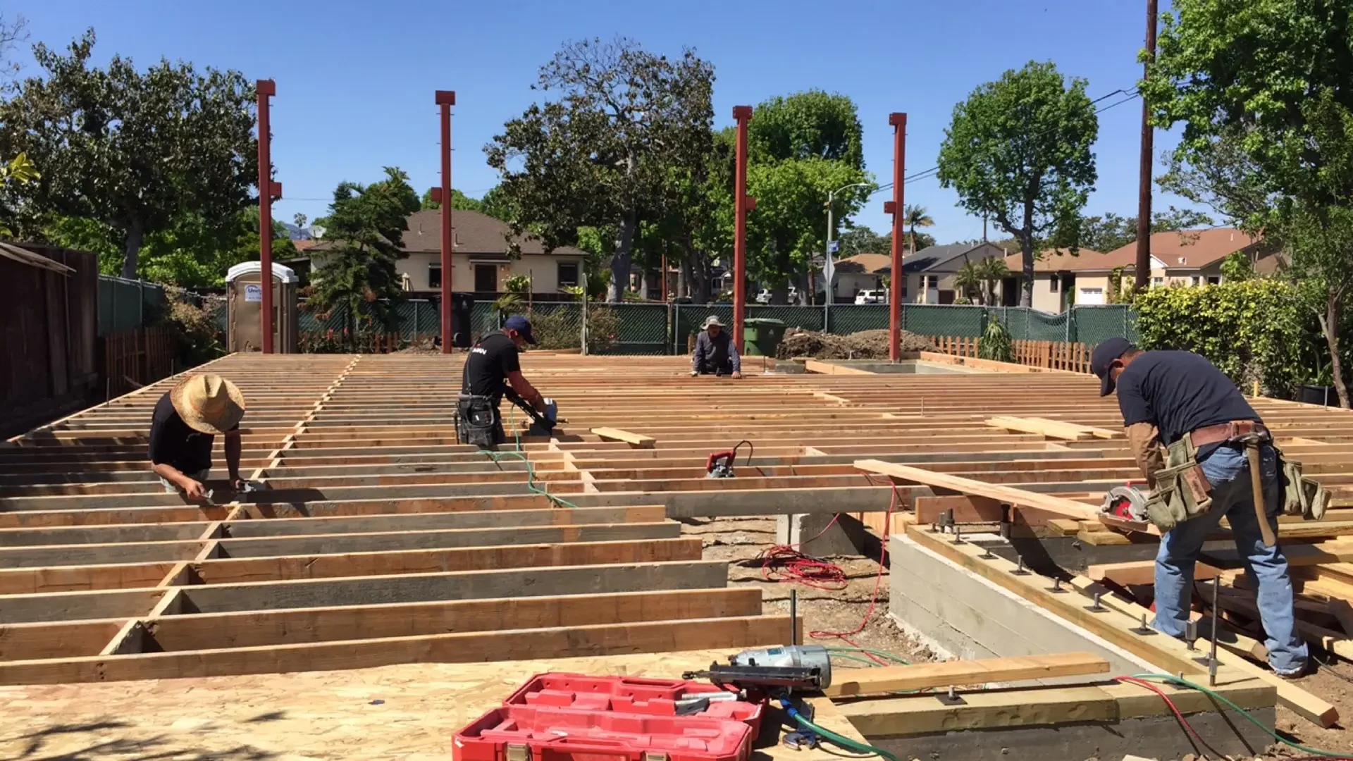 Construction workers building wooden house framework.
