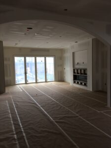 Empty room under construction with covered flooring.