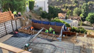 Construction workers building foundation at residential site.